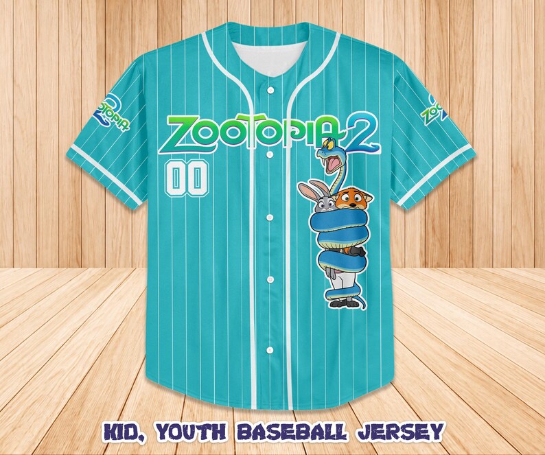 Op de afbeelding: Een turquoise honkbalshirt met witte krijtstrepen, met de tekst "Zootopia 2" en het nummer "00". Het shirt heeft een cartoonafbeelding van personages uit de film. De tekst "Kid, Youth Baseball Jersey" staat onderaan.