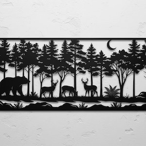 Könnte beinhalten: Schwarze Metall-Wandkunst, die eine Waldszene mit einem Bären, Hirschen, Bäumen und einem Halbmond darstellt. Das Silhouette-Design zeigt detaillierte Bäume und Wildtiere und schafft ein dekoratives Stück zum Thema Natur.