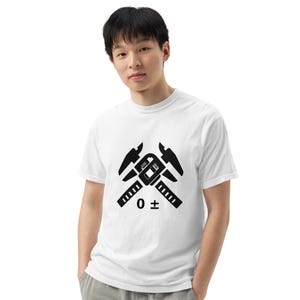 May include: White t-shirt with a black graphic of a caliper tool and the text "0 ±". The design is centered on the front. The shirt has short sleeves and a crew neck.