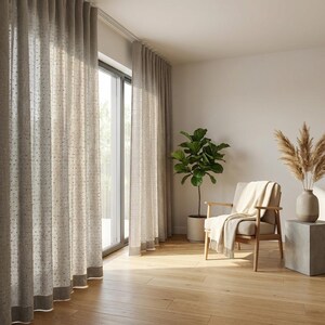 May include: Floor-to-ceiling beige curtains with a subtle dotted pattern and a solid hem, hanging from a track system. The curtains are semi-sheer, allowing natural light to filter through while covering a large glass sliding door panel.