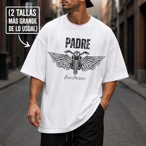 May include: A white oversized t-shirt featuring a black graphic of a motorcycle with large wings. The text PADRE is printed above the motorcycle, and Guía y Protector is printed below. A box in the corner reads (2 TALLAS MÁS GRANDE DE LO USUAL).