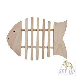 May include: A wooden fish-shaped trivet with a light brown finish. The trivet features a fish skeleton design with vertical slats and a tail fin. The trivet is designed to protect surfaces from hot dishes and is a decorative kitchen accessory.