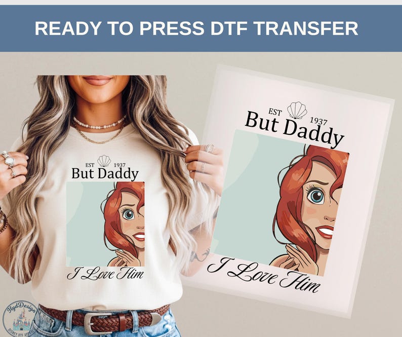 May include: A cream-colored t-shirt with the text "But Daddy" and the phrase "I Love Him" below a cartoon image of a red-haired woman. The words "READY TO PRESS DTF TRANSFER" are at the top.