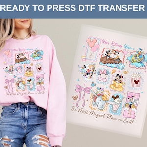 May include: A light pink sweatshirt with a colorful graphic featuring Disney characters and the text "Walt Disney World" and "The Most Magical Place on Earth." A DTF transfer with the same design is next to the sweatshirt.