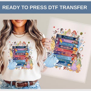 May include: A cream-colored t-shirt featuring a stack of illustrated books with titles like "Frozen" and "Tangled." The design includes various princess characters. The words "READY TO PRESS DTF TRANSFER" are at the top.