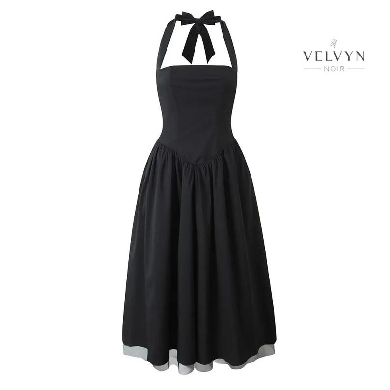 May include: A black halter dress with a bow at the neckline and a flared skirt. The dress has a fitted bodice and a midi length. The brand name "VELVYN NOIR" is printed in white on the right side of the dress.