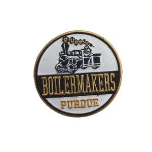 Puede incluir: Parche circular con fondo blanco, con una ilustración de tren negro y dorado. El texto "BOILERMAKERS" está en letras doradas, con "PURDUE" debajo. El parche tiene un borde dorado.