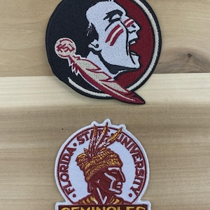 Può includere: Due toppe ricamate con il logo dei Seminoles della Florida State University. Una toppa è circolare con una testa di Seminole in bianco, rosso e nero. L'altra toppa è un disegno circolare con le parole "FLORIDA STATE UNIVERSITY" e "SEMINOLES".