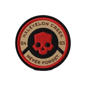 Puede incluir: Parche redondo con un diseño de calavera roja. El parche tiene un centro negro con las palabras "MALEVELON CREEK" y "NEVER FORGET" en color beige. También son visibles los números "04" y "03". El parche tiene un borde rojo.