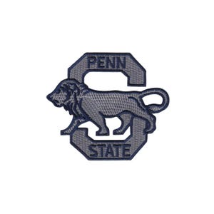 Pode incluir: Um patch bordado azul marinho com um leão e as palavras "PENN STATE" em uma fonte estilizada. O leão está em perfil, voltado para a esquerda, e está posicionado dentro de uma letra "S" azul escuro estilizada.