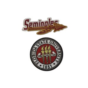 Puede incluir: Dos parches bordados. El parche superior dice "Seminoles" en rojo con una lanza dorada. El parche inferior es un diseño circular con "Florida State University" y "1851" en un borde negro.