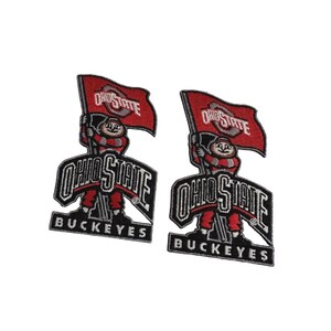 Può includere: Due toppe ricamate con la mascotte degli Ohio State Buckeyes. Ogni toppa ha una bandiera rossa con "OHIO STATE" in bianco, una figura della mascotte e le parole "OHIO STATE" e "BUCKEYES" in bianco e nero.