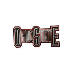 Può includere: Toppa ricamata con la scritta "OHIO STATE" in grassetto e a blocchi. Le lettere sono principalmente rosse con dettagli neri e bianchi, bordate di nero. La toppa rettangolare è progettata per essere applicata su abbigliamento o accessori.