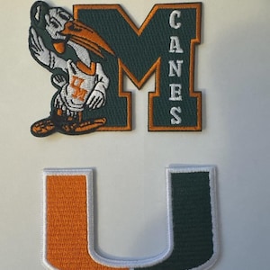 May include: Embroidered patches featuring the University of Miami Hurricanes logo. The patches include a green and orange "M" with "CANES" in white, a mascot, and a split orange and green "U" with white borders. Ideal for apparel.