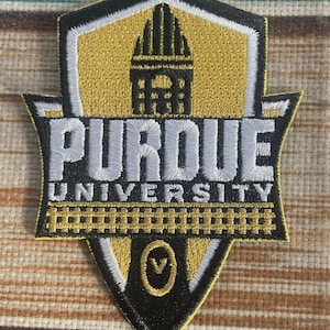 May include: Embroidered patch featuring the Purdue University logo. The patch is shield-shaped with a black border, gold and white accents, and the words "PURDUE UNIVERSITY" in white. A gold building graphic is at the top.