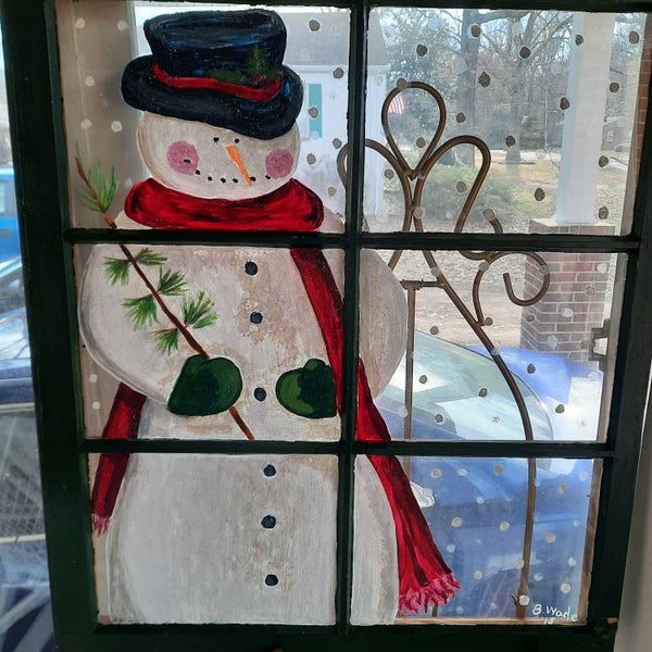 Snowman peeking through the window glass