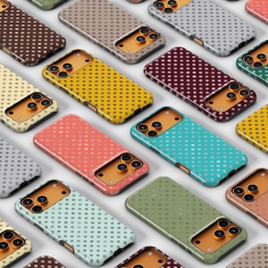 May include: A collection of colorful phone cases with a dotted pattern. The cases are in various colors, including yellow, teal, pink, and brown. The cases are arranged in a grid-like pattern, showcasing the variety of designs.