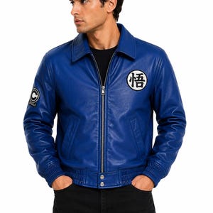 May include: A vibrant blue leather jacket featuring a classic collar, a full-length front zipper, and ribbed cuffs and hem. The chest displays a white circular patch with black Japanese kanji, while the sleeve features a Capsule Corp logo patch.