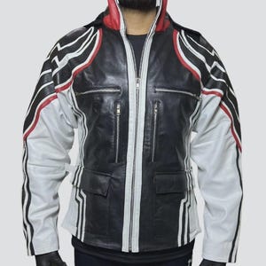 Può includere: Giacca in pelle nera con dettagli bianchi e rossi. La giacca presenta una cerniera a tutta lunghezza, due tasche sul petto e due tasche laterali. Le maniche sono bianche con strisce nere. Il colletto è rosso e bianco.