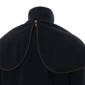 May include: A black coat featuring a detachable cape-style collar that wraps around the shoulders. The collar is secured with a prominent metal zipper that runs along the curved edge, meeting at the center back near the high neckline.
