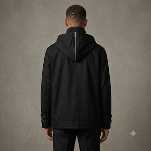 May include: A black hooded jacket featuring a prominent vertical metal zipper running down the center of the hood. The jacket includes long sleeves with adjustable buckled straps at the cuffs and a solid black finish throughout the garment.