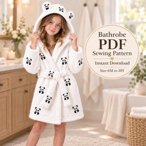 May include: A white plush bathrobe with a hood featuring panda ears and a repeating black and white panda print. The robe includes a matching tie belt. A circular graphic overlay displays the text: Bathrobe PDF Sewing Pattern Instant Download Size 6M to 10Y.