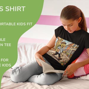 K&ouml;nnte beinhalten: Schwarzes Kinder-T-Shirt mit einer bunten Grafik einer Schildkr&ouml;te, die eine Stra&szlig;e entlangl&auml;uft. Auf dem Shirt stehen die Worte "KIDS SHIRT", "COMFORTABLE KIDS FIT", "DURABLE COTTON TEE" und "MADE FOR ACTIVE KIDS".