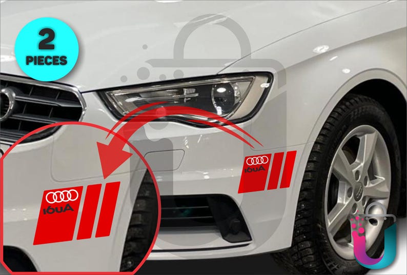 May include: White car with red and white decals. The decals feature the Audi logo and the word "IOUA" in white. The image shows two pieces of decals on the car's front bumper. The car has a black tire and a silver rim.
