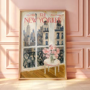 May include: A framed print of a July 1, 1974, The New Yorker magazine cover featuring an oil painting of a city skyline viewed through a window. A small round table with a vase of pink flowers sits in the foreground against a wrought iron balcony.