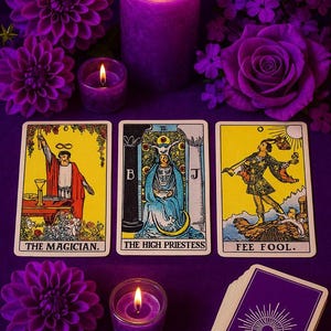 a tarot card spread with three cards, a lit candle, and purple flowers arranged on a purple background.