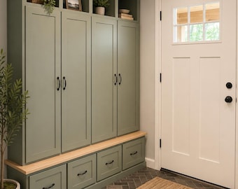 May include: A floor-to-ceiling sage green storage unit featuring four tall cabinet doors with black handles, an open shelving section at the top, and a bench base with four drawers. The unit includes a light wood bench top and black hardware.