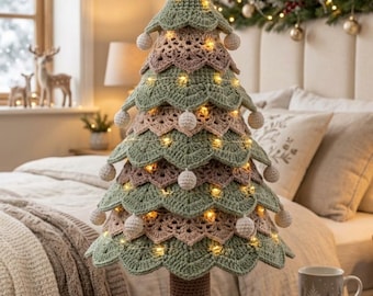 May include: A crocheted Christmas tree decoration featuring alternating layers of sage green and dusty rose yarn. The tree is topped with a crocheted star, adorned with small white pom-poms on the edges, and illuminated by thin string lights.