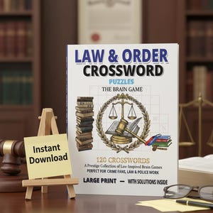 Puede incluir: Un libro titulado "Law & Order Crossword Puzzles: The Brain Game" con un gráfico de martillo y balanza de la justicia. La portada también indica "120 Crucigramas" y "Letra Grande". Un pequeño caballete de madera muestra una nota adhesiva amarilla que dice "Descarga instantánea".