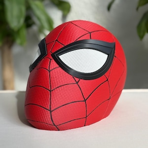 May include: A red Spider-Man mask with black web lines and black eye frames. The eye lenses are white with small perforations. The mask is made of a textured material.