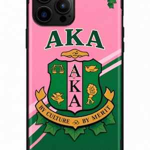 Puede incluir: Funda de teléfono rosa y verde con las letras "AKA" en verde, y un diseño de escudo. El escudo incluye balanzas, pájaros y un árbol, con las palabras "By Culture By Merit" en una pancarta. La funda tiene un borde negro.