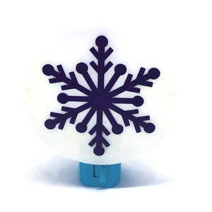 May include: A white night light with a blue switch and a dark blue snowflake design.