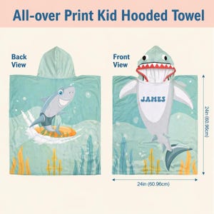 May include: An all-over print kid hooded towel featuring a shark theme. The back view shows a shark surfing, while the front view displays a shark hood with teeth and the name JAMES. The towel measures 24 inches by 24 inches as indicated by arrows.