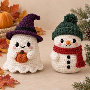 May include: Two crocheted figures: a white ghost wearing a purple witch hat and holding a small orange pumpkin, and a white snowman wearing a dark green beanie with a pom-pom and a red scarf, featuring black eyes, buttons, and pink cheeks.