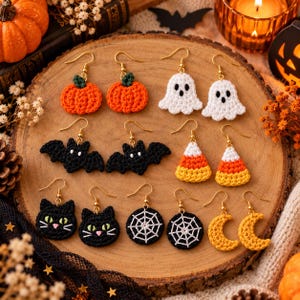 Può includere: Una collezione di dieci orecchini all'uncinetto a tema Halloween con zucche arancioni, fantasmi bianchi, pipistrelli neri, caramelle, facce di gatto nero, ragnatele bianche su cerchi neri e lune crescenti gialle con ganci dorati.