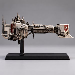 Könnte beinhalten: Ein detailliertes, cremeweißes Miniatur-Raumschiffmodell mit einer hohen, kathedralenartigen Turmstruktur am Heck, dunklen metallischen Akzenten und einem roten Schildeblem mit Totenkopf-Symbol am Bug, montiert auf einem schwarzen rechteckigen Sockel.