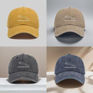 May include: Four baseball caps in mustard yellow, beige, charcoal gray, and navy blue. Each cap features a white embroidered Jaguar logo and the word JAGUAR centered on the front panel. The caps have a structured crown and a curved brim.