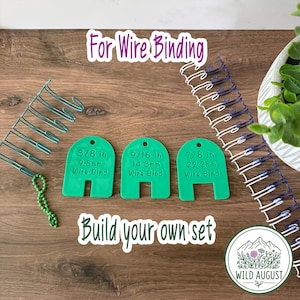 May include: Three green plastic wire binding measurement tools with text reading 3/8 in 9.5mm, 9/16 in 14.3mm, and 7/8 in 22.2mm Wire Bind. The image includes text For Wire Binding and Build your own set, with metal wire coils nearby.