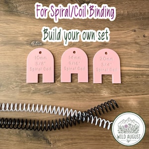 May include: Three light pink arch-shaped plastic gauges for spiral coil binding, labeled 10mm 3/8", 14mm 9/16", and 20mm 3/4". Below are two long plastic spiral coils in white and black. Text reads: For Spiral/Coil Binding, Build your own set.