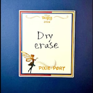 May include: A rectangular dry erase board with a white background, featuring the text "Dry erase" in black. The board includes the "Disney Destiny 2026" logo and a silhouette of a fairy with the words "Pixie Port".