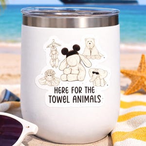 Może przedstawiać: Biały izolowany kubek z przezroczystą pokrywką, z naklejkami przedstawiającymi zwierzęta z ręczników i napisem "HERE FOR THE TOWEL ANIMALS". Tło przedstawia scenę na plaży z statkiem wycieczkowym na horyzoncie.