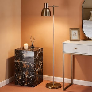 以下が含まれることがあります： 真鍮のフロアランプ、黒い大理石のサイドテーブル、白い化粧台を備えたモダンなインテリアシーン。サイドテーブルにはキャンドルとリードディフューザーがあります。額入りの写真と鏡も表示されています。