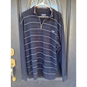 May include: Navy blue long-sleeve pullover sweater with horizontal blue and white striped design. Features a quarter-zip closure, a brown collar, and the K-Swiss logo on the chest.