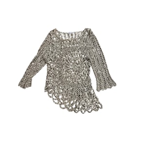 May include: A beige crochet top with long sleeves and a scalloped hem. The open weave design features a circular pattern at the center. The sleeves have a slight bell shape at the cuffs. The top is made of a soft, lightweight material.