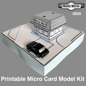 May include: A black and white printable micro card model kit of a small town store, "Mainly Mart", with a black toy car. The kit includes the store, a parking area, and a small car. The text "Printable Micro Card Model Kit" is at the bottom.