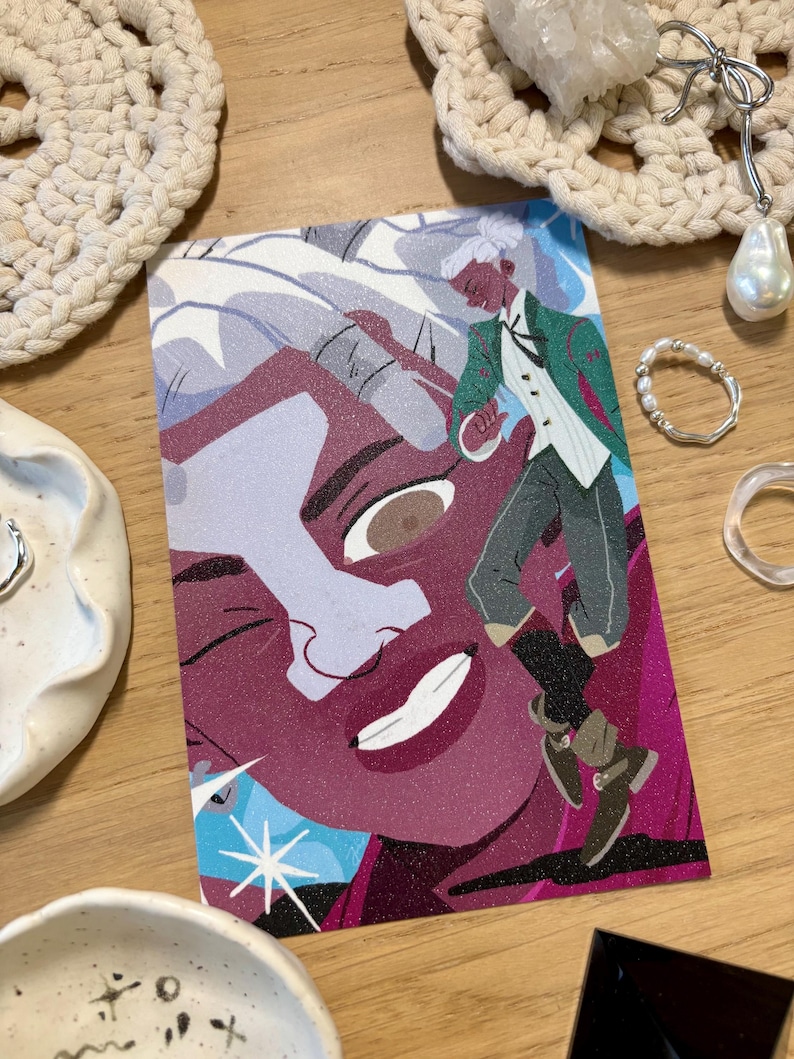Puede incluir: Una colorida impresi&oacute;n art&iacute;stica con una ilustraci&oacute;n estilizada de una persona con chaqueta verde y chaleco blanco, sobre un gran rostro. La impresi&oacute;n tiene un aspecto brillante y texturizado, colocada sobre una superficie de madera, rodeada de joyas y objetos decorativos.